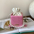 Macro detail of pink snakeskin pattern bag with pearl handle and golden chain - Pink