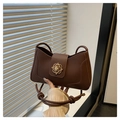 Dettaglio della borsa a tracolla retrò in pelle marrone scuro con fibbia dorata - caffè