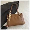 Detail of caramel tote bag with white contrast stitching and a patterned silk scarf - Tan