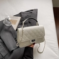 Bolso bandolera acolchado blanco crema con cierre plateado y cadena sobre una americana - Blanco