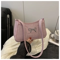 Close-up of pink glitter underarm bag featuring a silver metal bow accent - Pink