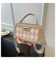 Close-up of beige argyle pattern on handbag with gold hardware and fabric strap - Khaki