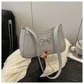 Dettaglio di una borsa argento glitterata con fiocco metallico e trama scintillante - Argento