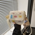 Sac bandoulière beige avec écussons dessin animé, breloque peluche et dentelle - Avec Pendentif / Blanc