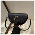 Dettaglio di una borsa a sella in pelle nera opaca con fibbia metallica dorata a semicerchio - Nero