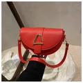 Dettaglio della borsa a sella rossa con fibbia a triangolo d'oro e tracolla in pelle - Rosso