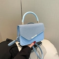 Light blue faux leather handbag featuring woven flap design and gold hardware accents - Blue