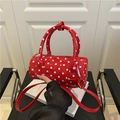 Bolso cilíndrico rojo con lunares, acabado brillante y correa de hombro ajustable - Rojo