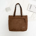 Detail of dark brown faux suede tote bag featuring front zipper pocket and minimalist patch - Brown