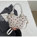 Dettaglio della borsa a secchiello con stampa ciliegia e finiture metalliche dorate - Bianco Sporco