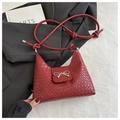 Bolso trenzado color burdeos con lazo metálico plateado y correa larga con nudos - Rojo