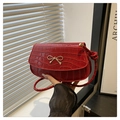 Bright red crocodile texture crossbody bag with a golden metal bow and glossy finish - Red