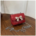 Dettaglio mini borsa a tracolla rossa con fiocco in metallo argento e cinturino a catena - Rosso