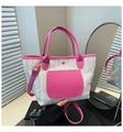 Detail of woven tote bag featuring pink lychee grain leather trim and magnetic buckle - Pink