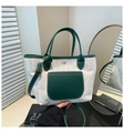 Detailed shot of straw tote with green leather trim and adjustable shoulder strap - Green