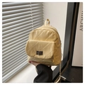 Gros plan d'un mini sac à dos matelassé jaune pâle avec fermoir tournant et chaînes dorées - Jaune