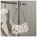 Detail of white baguette bag with cherry print and metallic chain strap on hanger - White