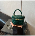 Macro detail of dark green quilted leather vanity bag with gold chain and handle - Green