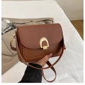 Detail of contrast stitching and golden U-shaped metal buckle on the brown shoulder bag - Brown