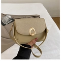 Detail of khaki saddle bag with woven texture lid and golden horseshoe buckle - Khaki
