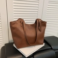 Bolso tote vintage marrón grande en cuero PU texturizado sobre libros blancos elegantes - Marrón