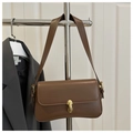 Détail du sac à main vintage marron avec fermoir ovale doré sur un présentoir - Marron