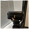 Detailansicht einer schwarzen Baguette-Tasche mit edlem goldenen Metallschloss-Verschluss - Schwarz