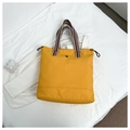 Detail of yellow canvas tote bag with multi-color striped handles and side drawstring - Yellow