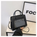 Detail view of black faux leather Ita bag with clear window, handle, and shoulder strap - Black