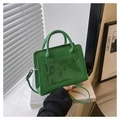 Detailed view of green leather crossbody bag with a modern transparent PVC pocket design - Green