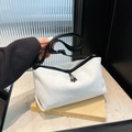 Minimalist white crossbody dumpling bag with wide black strap on artistic props - White