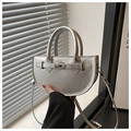 Detalle de bolso de media luna plateado metálico con cierre de giro y asa elegante - Plateado