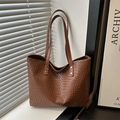 Brown woven tote bag with long shoulder straps and silver rivets on window sill - Brown