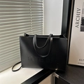 Bolso tote minimalista de cuero negro mate con relieve en estante moderno - Negro