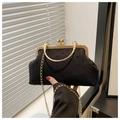 Detailed view of black textured shell evening bag with vintage gold metal frame and handle - Black