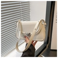 Detail of white leather shoulder bag featuring a polished silver heart-shaped buckle closure - White