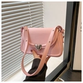 Detailed close-up of a pink matte leather handbag with a silver heart-shaped metal lock - Pink