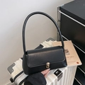 Minimalist black faux leather baguette bag with a sleek gold metal buckle and shoulder strap - Black