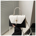 Detail of minimalist black and white crossbody bag with golden round clasp and fine stitching - White