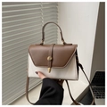 Detail view of contrast color stitching and gold buckle on a retro crossbody bag - Brown