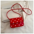 Retro red crossbody bag with white polka dots and long shoulder strap in urban setting - Red