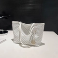 Gros plan d'un sac cabas blanc à motifs M gris et pendentif en métal doré - Blanc