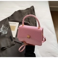 Detailed view of pink crossbody bag with textured flap and elegant gold hardware details - Pink