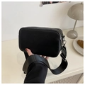 Detail of minimalist black crossbody camera bag featuring double silver zippers and wide strap - Black