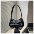 Detail shot of a black shoulder bag with a large bow decoration and metal zipper - Black