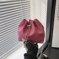 Pink woven drawstring bucket bag with silver chain and pearl charms held by hand - Dense Woven Texture / Rose Pink