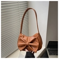 Close-up of caramel faux leather shoulder bag featuring a large decorative bow - Brown
