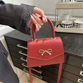 Mini red crossbody bag with golden bow clasp and top handle for women - Red