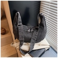 Close-up of black washed denim hobo bag with silver zipper and decorative double tassels - Black