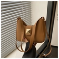 Detail of caramel brown hobo bag featuring a gold square pyramid clasp and leather strap - Brown